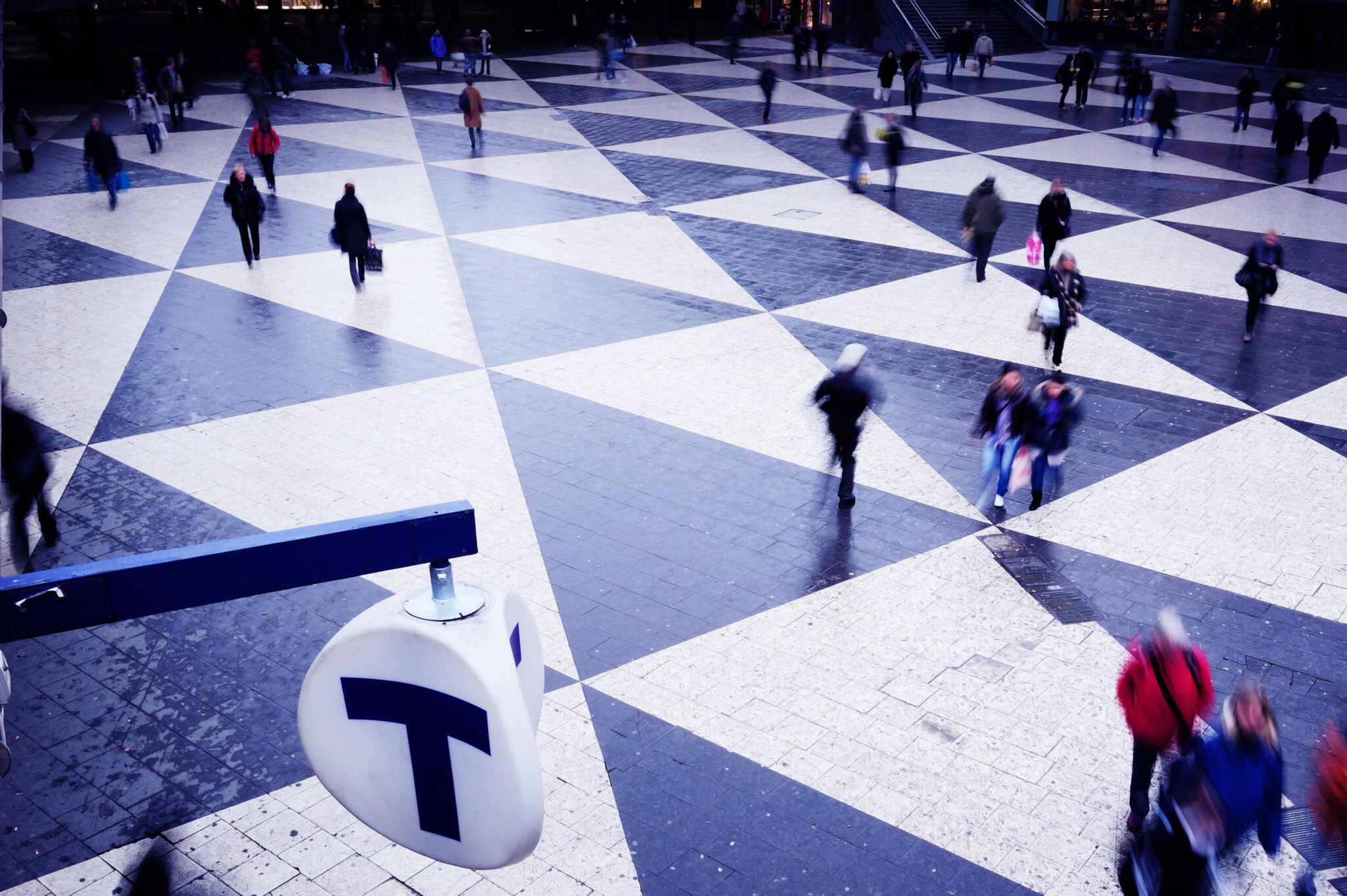people walking over a black and white geometric floor