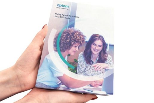 hands holding a copy of Aptem's "Using Aptem to prepare for DfE audit" guide